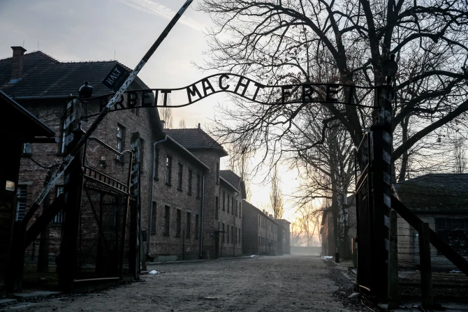 The sun rises over the main gate with the renowned sign “Arbeit Macht Frei” (“Work makes you free”) of the Museum of Auschwitz/Birkenau German Nazi concentration and extermination camp on the 80th anniversary of the liberation of the camp, Monday, Jan. 27, 2025. | Credit: Dominika Zarzycka/SOPA Images/LightRocket/Getty Images