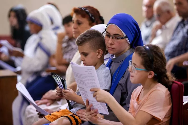 A nun of the Incarnate Word sits with children during Sunday morning Mass at the Church of the Holy Family in Gaza City on July 20, 2025. (photo: OMAR AL-QATTAA / AFP via Getty Images)