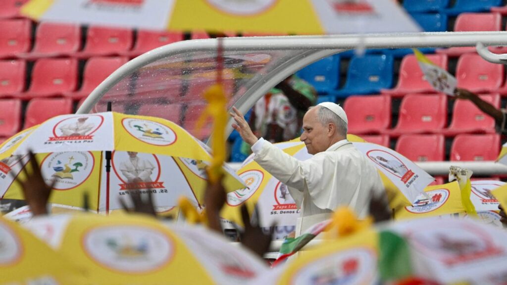 Pope Leo XIV greets a crowd under umbrellas during a meeting with families at Bata Stadium in Equatorial Guinea, Wednesday, April 22, 2026. | Credit: Vatican Media