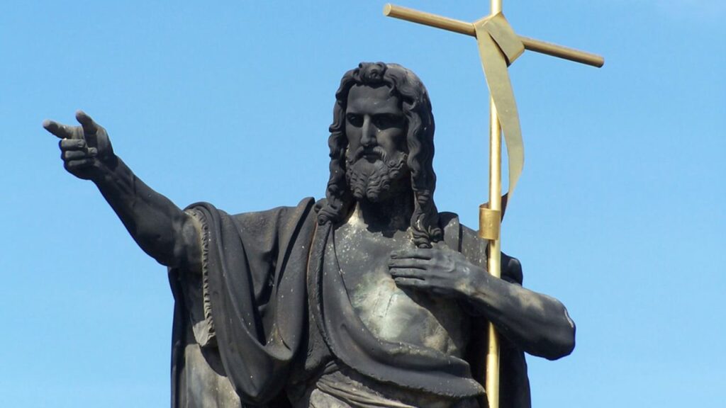 Statue of St. John the Baptist with golden cross, Charles Bridge, Prague, Czech Republic. | Credit: Oldrich Barak/Shutterstock