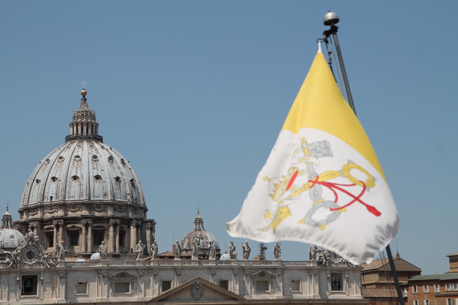 The flag of Vatican City with St. Peter’s Basilica in the background. | Credit: Bohumil Petrik/EWTN News