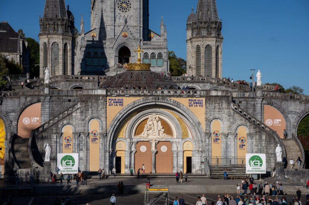 Mosaics by Marko Rupnik on the façade of the Basilica of the Rosary at the Sanctuary of Our Lady of Lourdes have been covered with banners ahead of Pope Leo XIV’s visit to France in September 2026. | Credit: Pierre Vincent/Sanctuary of Our Lady of Lourdes