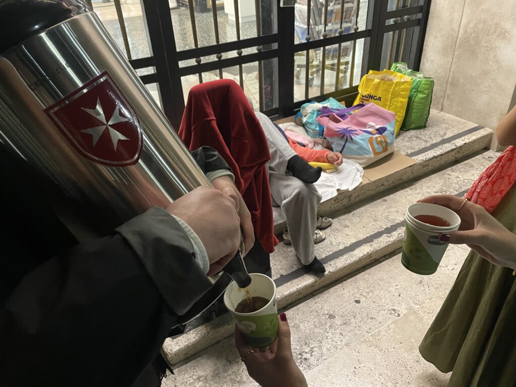Young volunteers distribute hot tea to the homeless near St. Peter’s Square in Rome on Oct. 13, 2026. | Credit: Patricia Ocando/EWTN News