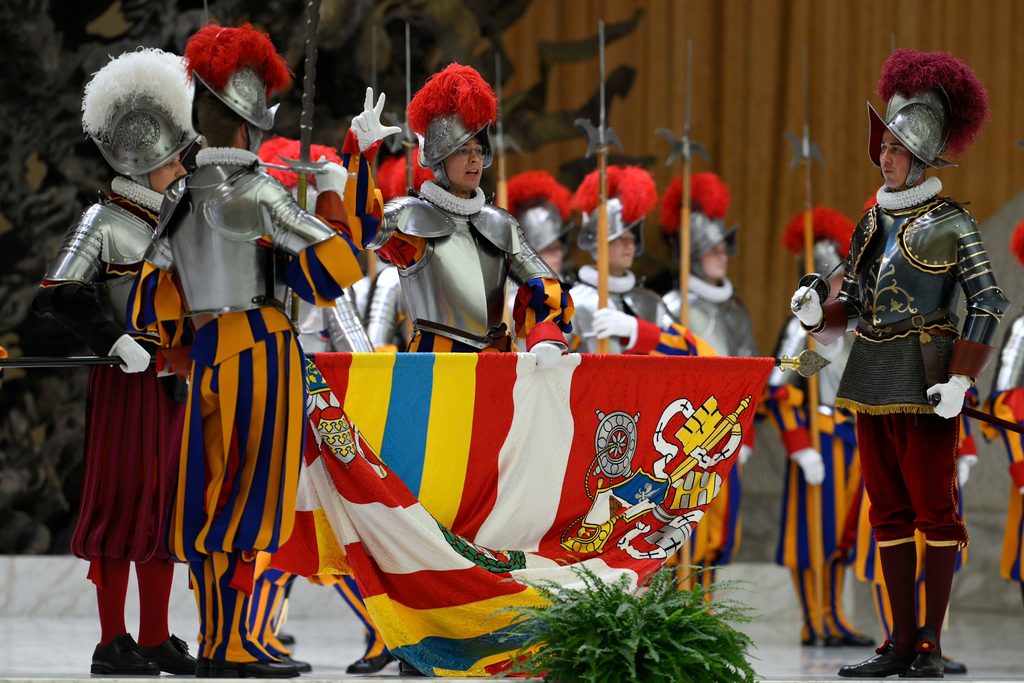 A Swiss Guard recruit holds a banner and raises his right hand while taking an oath to protect the pope, even at the cost of his own life, during a swearing-in ceremony at the Vatican on Oct. 4, 2025. | Credit: Vatican Media