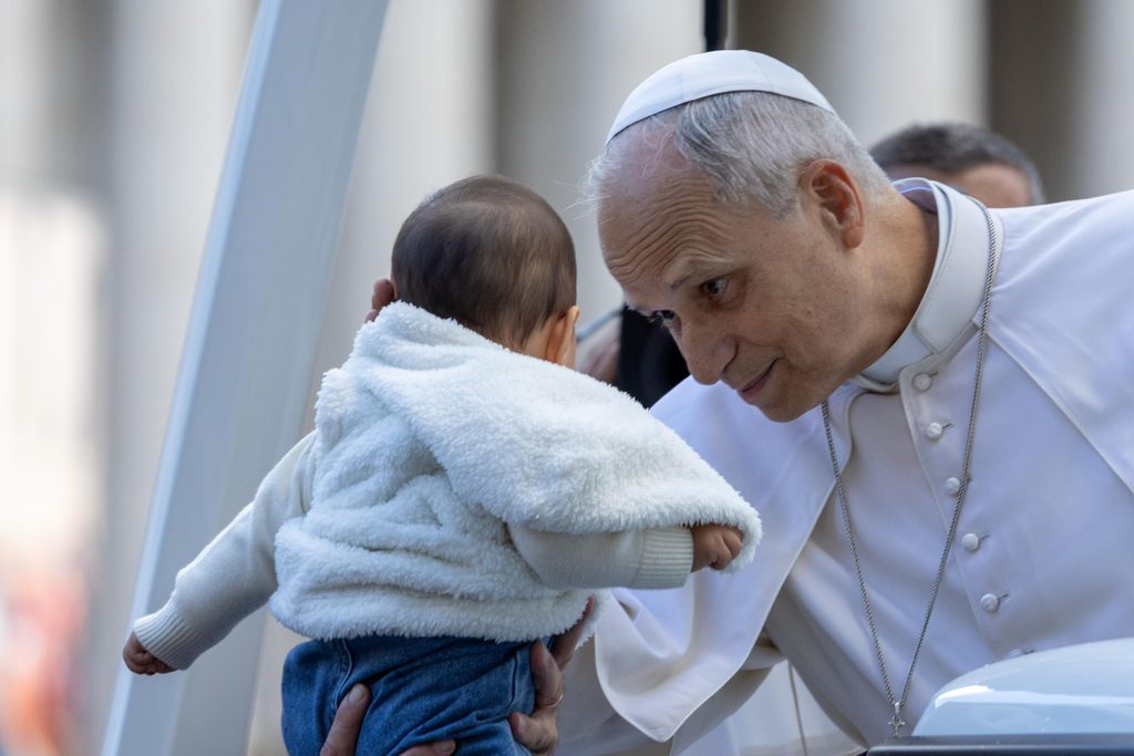 Pope Leo XIV leans down to bless a baby while greeting the crowds during his general audience in St. Peter’s Square on Oct. 21, 2026. | Credit: Daniel Ibañez/EWTN News